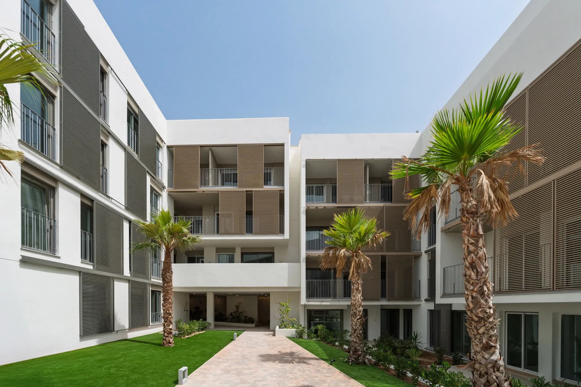 Groene binnentuin met palmen tussen de gebouwen