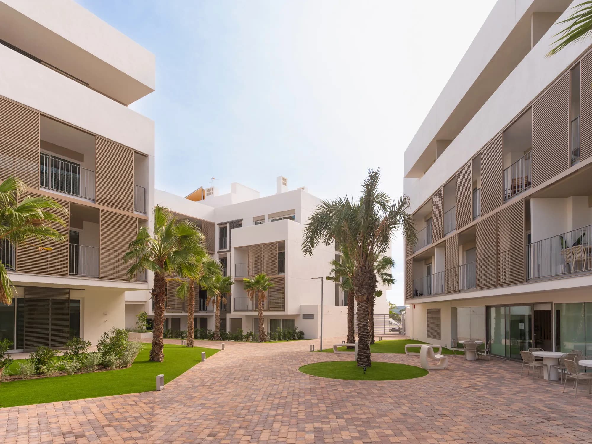 Binnentuin van het complex met palmen en zitplekken
