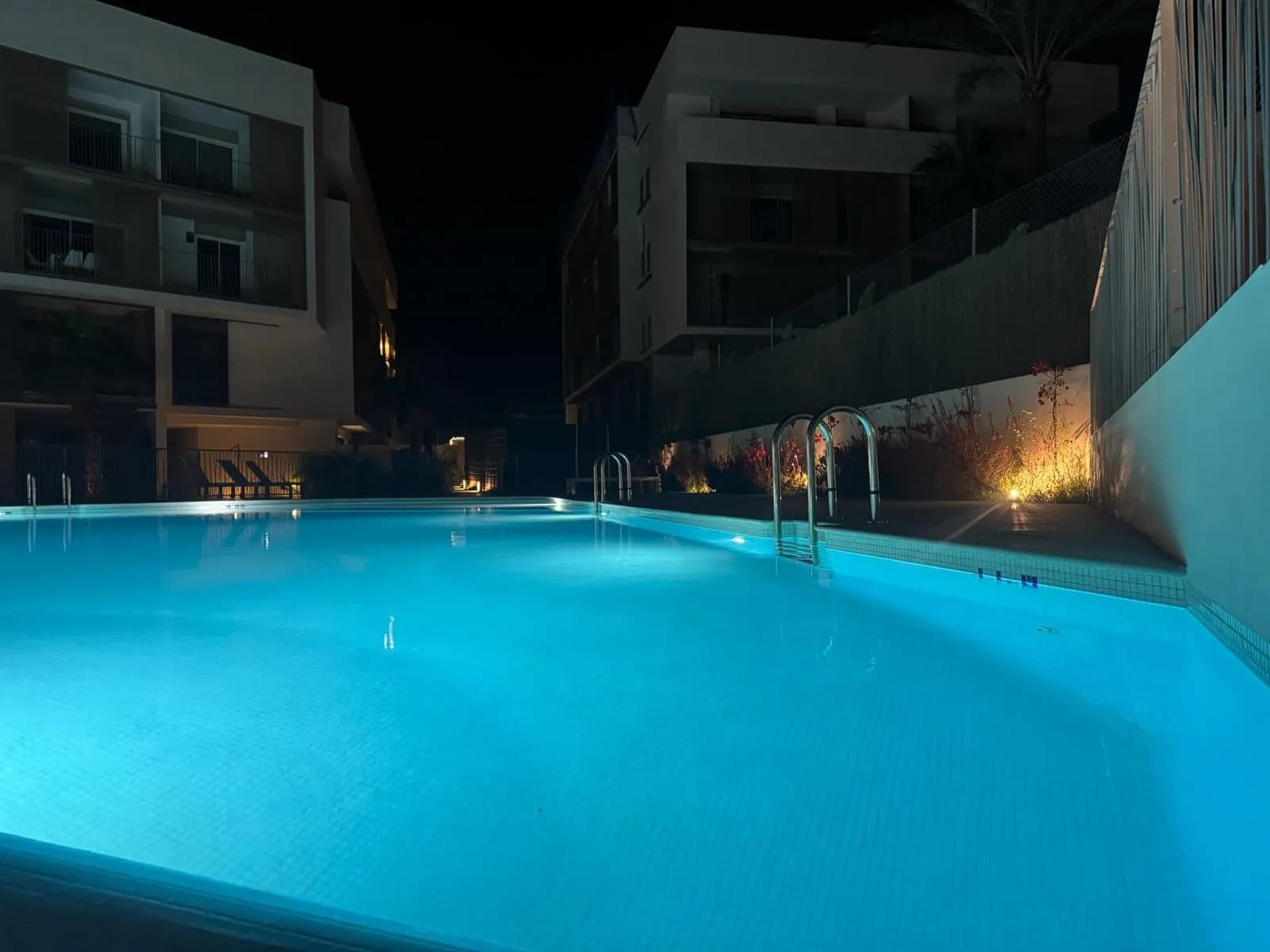 Het verlichte buitenzwembad in de avond